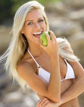 une fille mange une pomme pour maigrir de 10 kg par mois